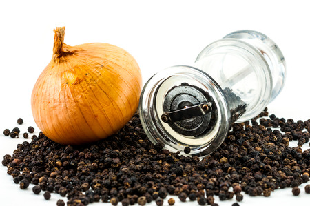Bottom of glass pepper Grinder and fresh onion with dried whole peppercorn on white backgroundの写真素材