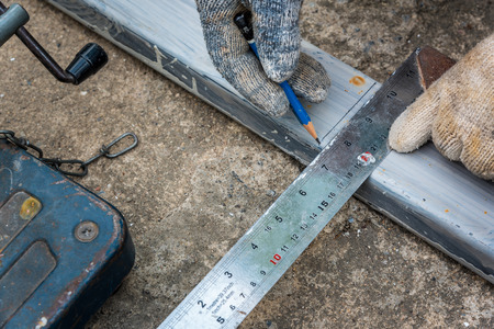 Worker measurement the steel with square triangle scale to preparation for cutting steelの写真素材