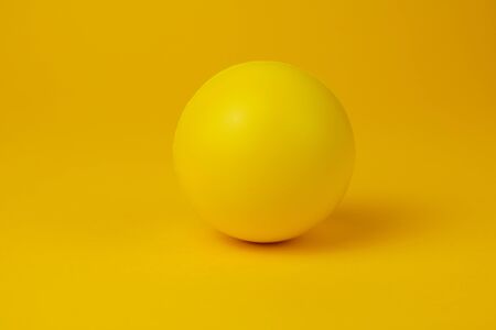 Yellow glossy game ball close-up on a yellow background.の写真素材