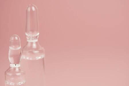 Glass medical ampoules on a pink background close-up, copy space,selective focus.の写真素材
