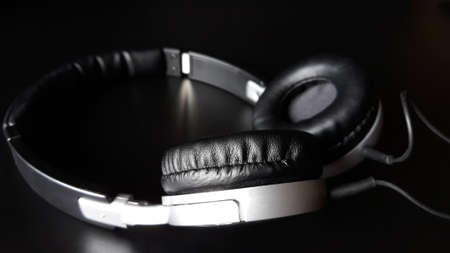 Black headphones isolated on a black background, close up.の写真素材
