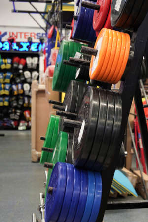Sports goods sale in store, colorful weight plates.Healthy lifestyle concept, sports training.Close-up colorfull barbell plates.のeditorial素材