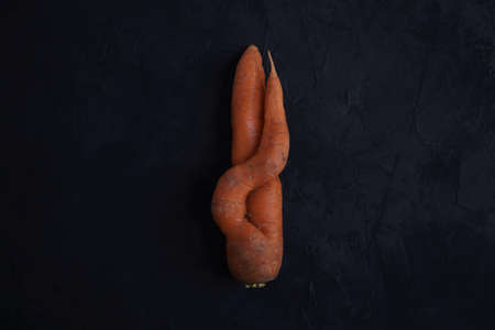 Fresh ugly carrots a black background, collected in a vegetable garden.View from above, close-upの写真素材