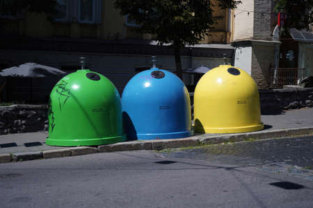 Three colored bins for sorting waste located in the city on the street.Trash Containers for Garbage Separation - three colors for plastic, metal and burnablesの写真素材