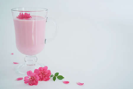 Rose moon milk for a better sleep with copy space. Ayurveda warm drink consumed before bed. Nice in case of sleeplessness. White background, close-up.の写真素材