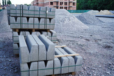Concrete curbs on wooden pallets stand on the street during street repair. Road works, sidewalk repairの写真素材