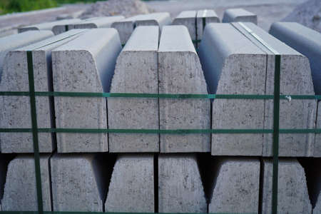 Concrete curbs on wooden pallets stand on the street during street repair. Road works, sidewalk repairの写真素材