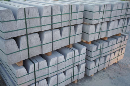 Concrete curbs on wooden pallets stand on the street during street repair. Road works, sidewalk repairの写真素材