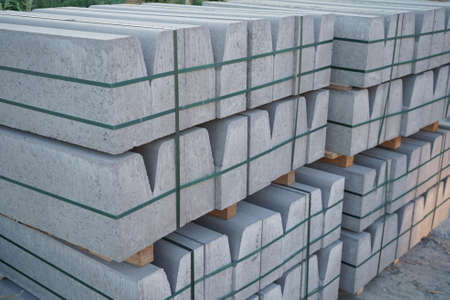 Concrete curbs on wooden pallets stand on the street during street repair. Road works, sidewalk repairの写真素材