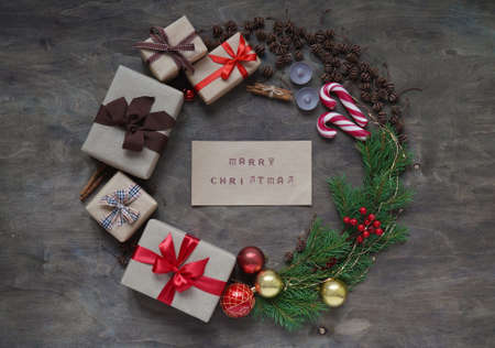 Christmas wreath made gift boxes, Christmas tree branches, pine cones, Christmas toy balls, candles,...