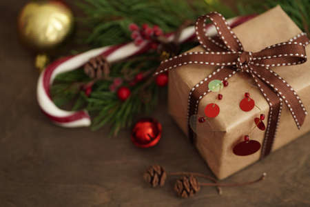 Christmas decorations.Gift box, Christmas candy, fir branches, balls on a wooden background, selective focus.Christmas and New Year concept.View from aboveの写真素材