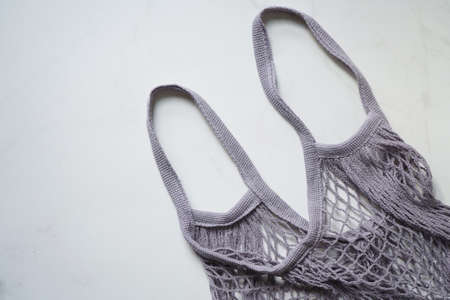 Shopping bag string bag mesh bag gray on white marble background, flat lay, top view. Concept zero wasteの写真素材