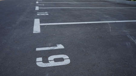 Close-up of a white paint number marking in a parking lot. Empty parking lot, Parking lot with white mark, Open parking in public park. Number 19の写真素材