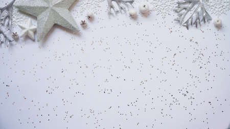 Christmas and New Year white and silver decorations among sparkles on white background, top view,...