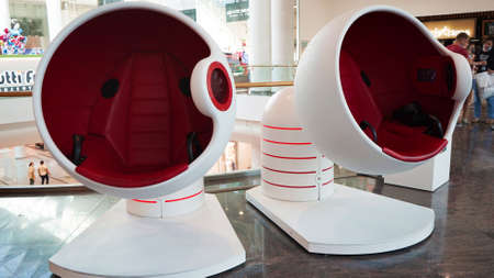 White and red round chairs of virtual reality in the lobby of a shopping center, modern...
