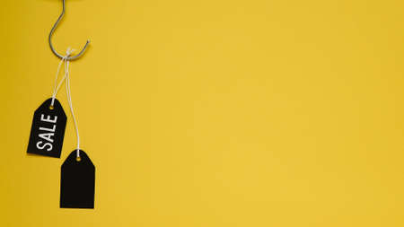Banner concept for Black Friday celebration, lettering. Black clothes hanger with black blank tags...