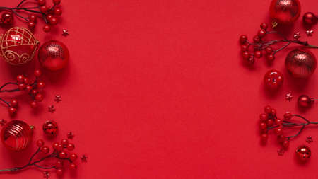 Concept for New Year and Christmas banner.Christmas decor, red balls, berries and stars on a red background, top view, flat lay, copy space.Christmas card with place for text, lettering.の写真素材