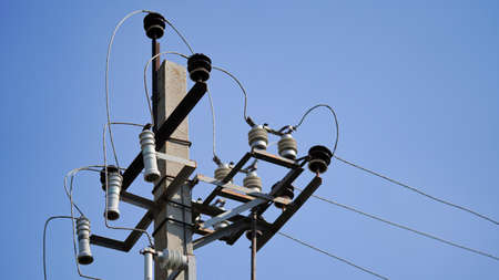 Close-up high voltage power line on a background of blue sky on a sunny day. Electro pole, pole with...