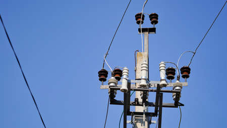 Close-up high voltage power line on a background of blue sky on a sunny day. Electro pole, pole with...