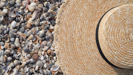 Close-up of a straw hat lies on the background of small sea shells on the beach,copy space.The concept of vacation,vacation,summer vacation.Seaside resort,travelの写真素材