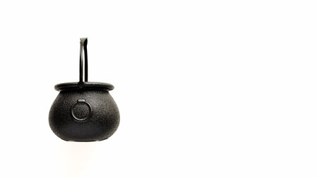 Closeup black witch pot on white background,top view,flat lay,copy space.Decor concept for Halloween...