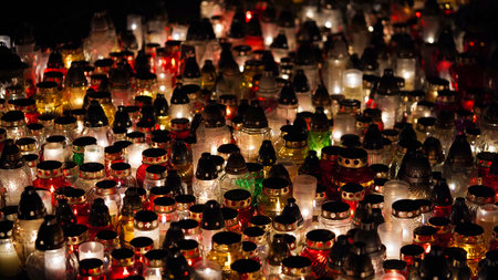 Lot of burning candles at night in cemetery.Glass inextinguishable lamps for cemetery.Day of remembrance and mourning for the dead.All Saints' Day.Commemorative candles as decor.Cemetery lampsの写真素材
