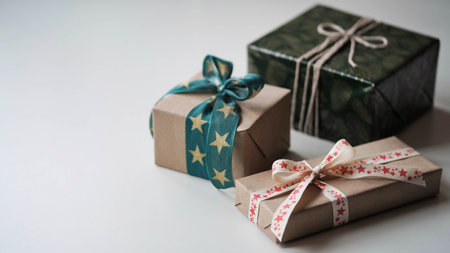 Close-up of three gift boxes with beautiful bows of ribbons with a pattern of stars on a white...