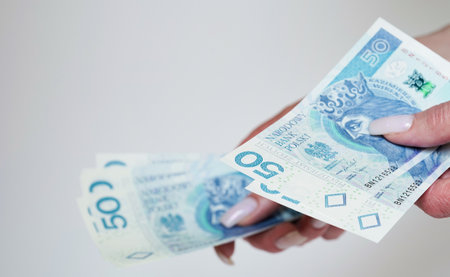 Close-up of female hands counting money,salary in zlotys,Polish currency.Concept of currency exchange in another country.Inflation and taxes in European Union.Payment for purchases.Copy spaceの写真素材