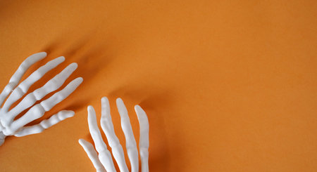 Skeleton of human hands on an orange background, top view, copy space.の写真素材