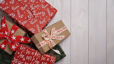 Close-up of many Christmas gifts lying on a white wooden table, top view, flat lay, copy space. Christmas and New Year banner conceptの写真素材