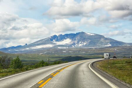 Open road in the Dovre national park, the view of the mountain Snowhettaの写真素材