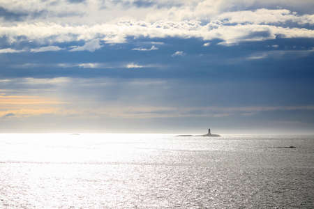 Norwegian coastline, lighthouse in the Norwegian sea at the sunset