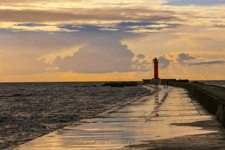 Colorful stormy sunset at the Rigas bay with Mangalsala light houseの写真素材