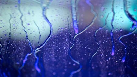Colorful water drops on the glass while rainの写真素材