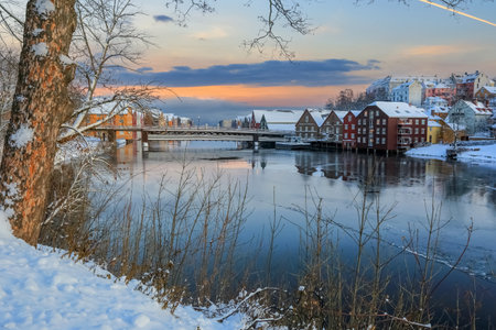 Winter in Trondheim, view of the river Nidelva and the historical old timber buildings  in the district Bakklandet reflected in the waterの写真素材