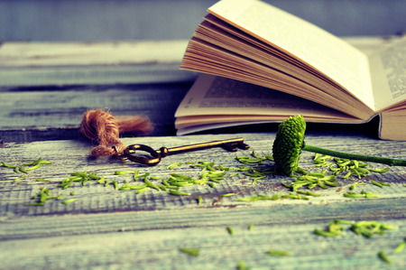 Open book with key on a wooden backgroundの写真素材