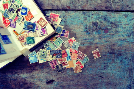 Old post stamps on a wooden backgroundのeditorial素材