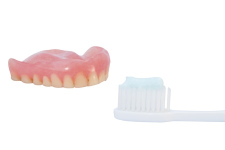 Denture and toothbrush isolated on the white background