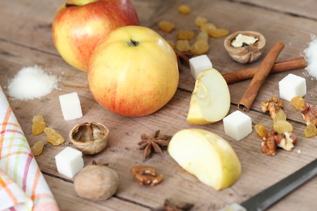 Ingredients for apple pie cooking. Ripe apples, sugar, cinnamon, raisin and nuts on a wooden background.の写真素材