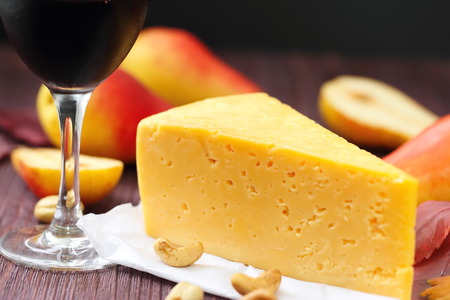 Piece of cheese with pears and nuts and glass of red wineの写真素材