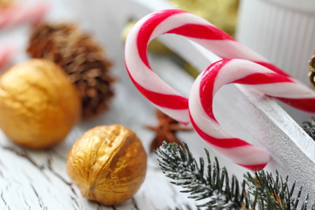 Christmas card. Coffee cups, christmas tree, assortment of sweetness, candy canes and festive decorations on wooden background.の写真素材