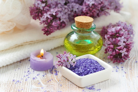 SPA setting with candles, aroma oil and lilac flowersの写真素材