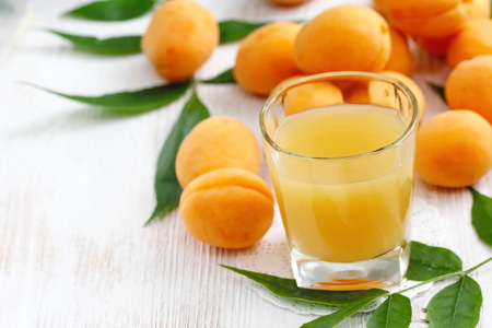 Apricot juice and ripe fresh apricots on the tableの写真素材