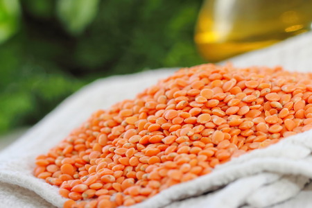 Red lentil on a wooden table ready for cookingの写真素材