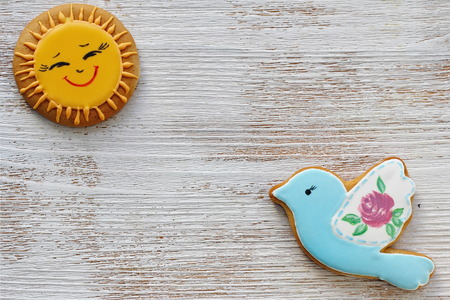 Wooden background with bird and Sun. Spring background with gingerbread for decorationの写真素材