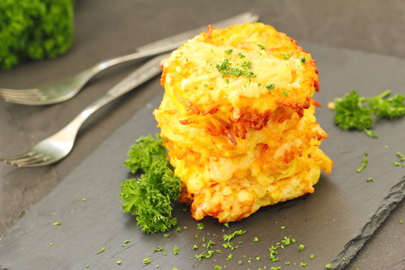 Fried potato pancakes with fresh parsley on a plateの写真素材