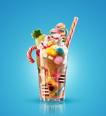 Colourful, festive cocktail with sweets, candy, jelly. Colorful array of different childs sweets and treats in cacao glass on blue background. Sweet candies cociailの写真素材