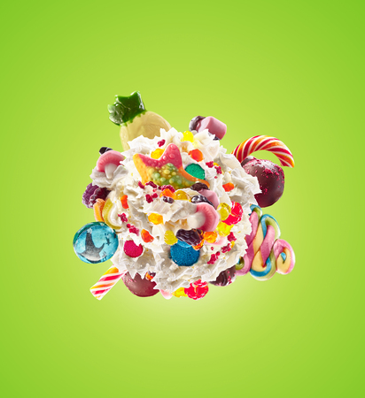 Milk shake with sweets and whipped cream, round form top view. Crazy freakshake food trend.の写真素材