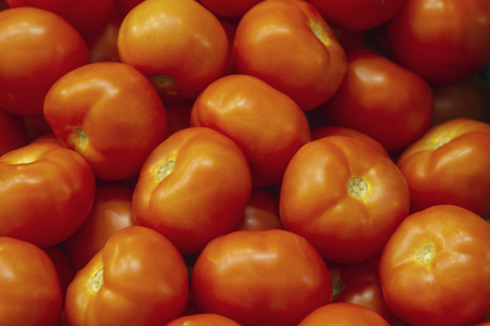 Fresh red tomato lying on the market counter. Red tomatoes texture, bright healthy vegetables and vegetatarian texture of red tomatosの写真素材
