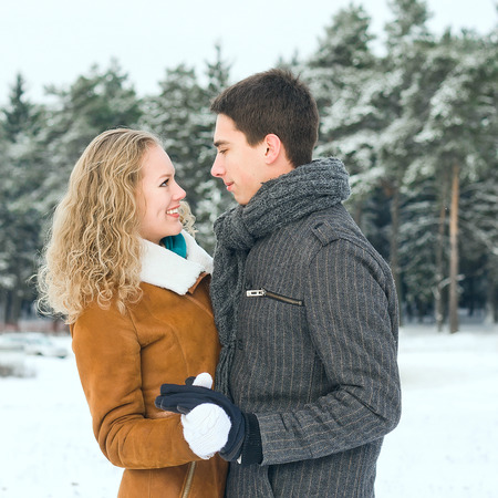 Outdoor happy couple in love posing in cold winter weatherの写真素材